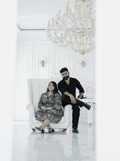 Another angle of the couple in the white room, framed by a doorway, creating a clean and modern composition.