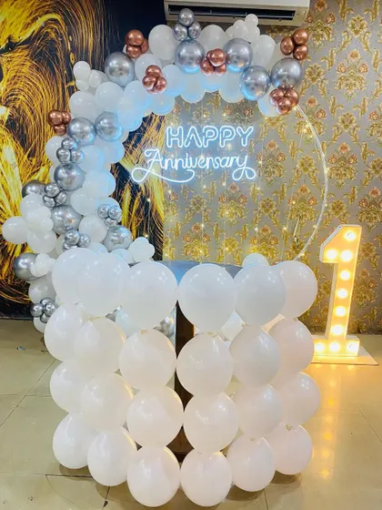 This view shows the cake table made of balloons, part of the elegant first-anniversary setup.