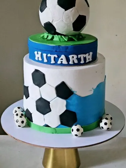 Another view of the rotating football cake, showing the clean design and the fun, miniature soccer balls at the base.
