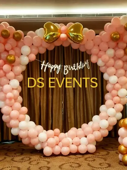 A cute Minnie Mouse-themed photo booth. I created a circular frame made entirely of pink, white, and gold balloons, complete with Minnie's signature bow on top, perfect for capturing memories.