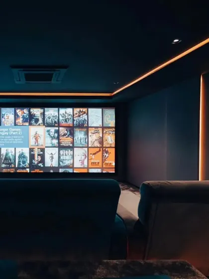 The same theater with the lights dimmed and the screen on. The ambient cove lighting provides just enough glow to navigate the room without affecting the picture quality.