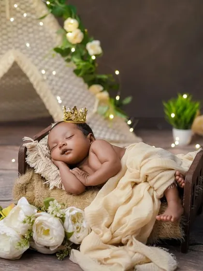 A royal nap. The combination of the rustic bed, fairy lights, and a tiny crown makes for a truly magical and memorable portrait.