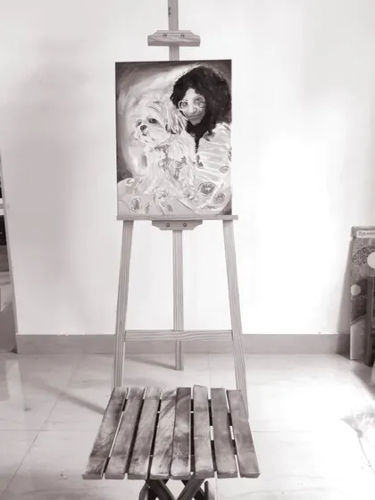 The finished monochrome portrait of a woman and her dog, displayed on an easel in my studio. This custom artwork is now ready to be sent to its new home, serving as a beautiful memory for the owner.