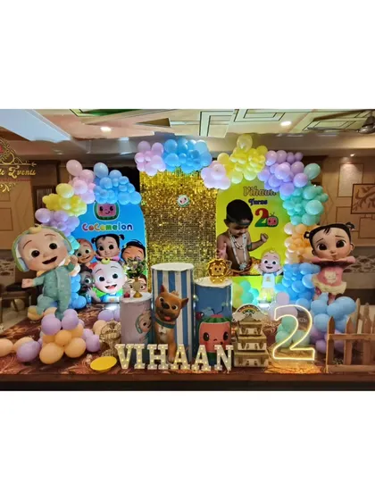 Here is another take on the Cocomelon theme, featuring a custom backdrop, themed plinths, and a picket fence prop. The child's name is spelled out in marquee letters, making it a personalized photo corner.