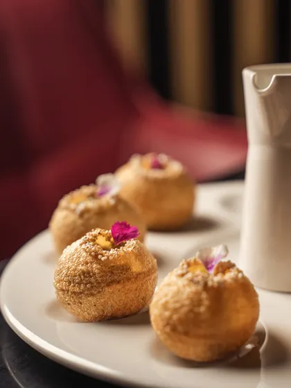 A macro shot focusing on the delicate flower garnishes on gourmet pani puris. This level of detail emphasizes the care and artistry that goes into preparing the dish.