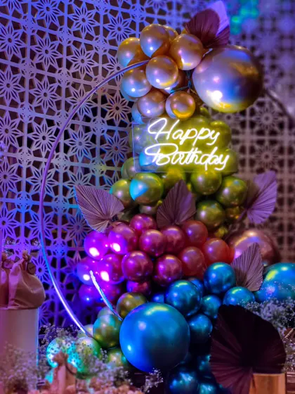 A mesmerizing circular ring backdrop with iridescent chrome balloons and a "Happy Birthday" neon sign. This is designed to capture those perfect, Instagram-worthy moments at a milestone birthday.