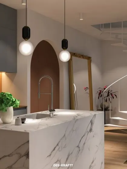 A minimalist kitchen featuring a striking white marble island with dramatic veining. The arched doorway and spiral staircase in the background add unique architectural interest.