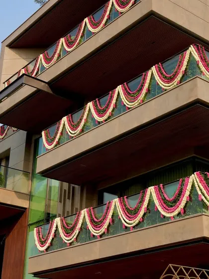 The entire building facade is dressed in floral garlands, announcing the celebration to the world. This is how we extend the event's design beyond the main venue.