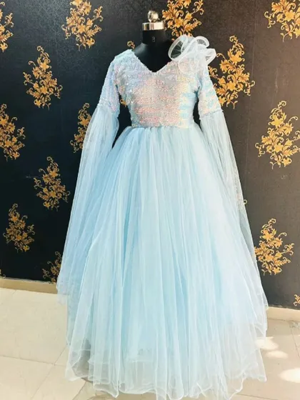 This sky blue ball gown features long, flowing bell sleeves and a sequined bodice. It's a unique and ethereal rental piece, perfect for a fantasy-themed photoshoot.