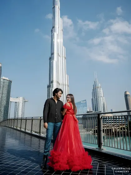 Our rental gowns are perfect for destination photoshoots. This couple chose a bold red ruffled dress for their session in Dubai, standing out against the iconic city skyline.