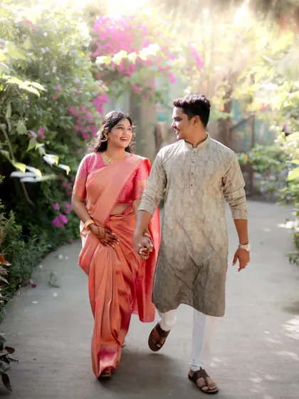 The couple takes a stroll hand-in-hand down a sunlit path, a perfect candid moment from their engagement session.