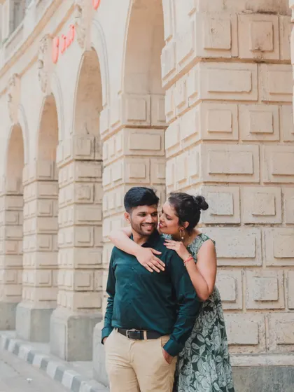 An intimate moment shared between a couple, using the strong lines and textures of Mumbai's stone architecture to frame their connection.