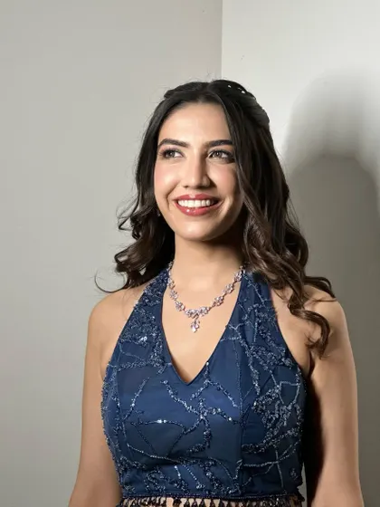 A confident and glamorous portrait. The bold lip and sparkling eyes are the perfect complement to her stylish blue halter-neck lehenga.