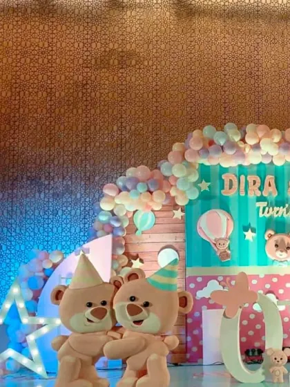 A cute teddy bear theme for a first birthday, with two large teddy bear mascots and a pastel color scheme.