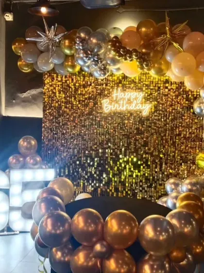 Another look at the masterpiece we created for a 65th birthday. This angle highlights the shimmer wall and the full balloon arch, showcasing a truly premium decor option.