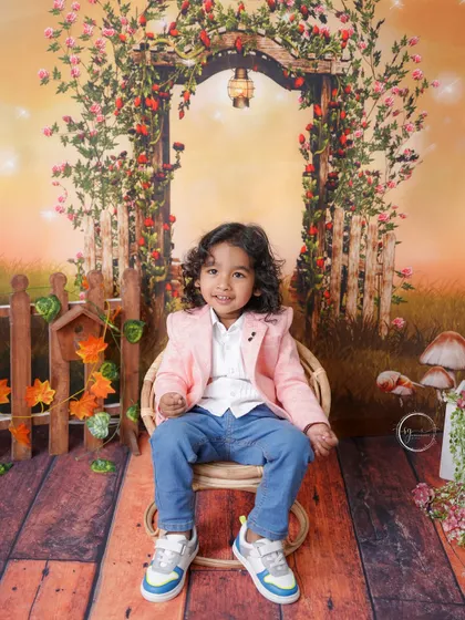This charming two-year-old is dressed in a stylish pink blazer for his enchanted garden photoshoot.