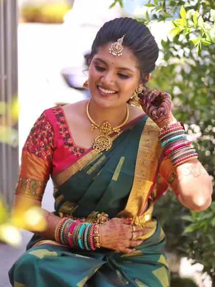 A beautiful moment of the bride adjusting her earring. This shot highlights the colorful bangles and how the warm tones in the makeup harmonize with the entire ensemble.