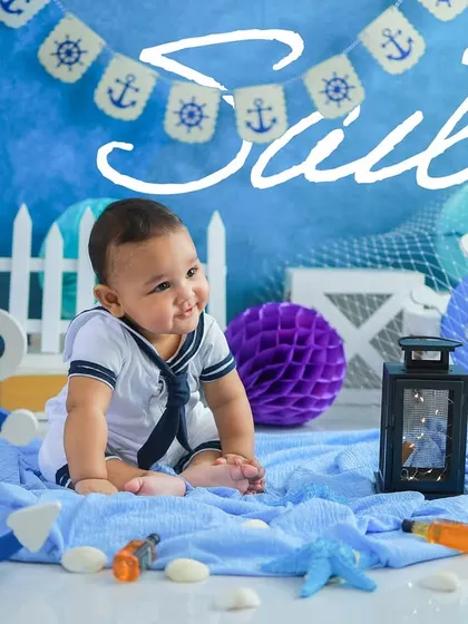 This little captain is ready to set sail. The text overlay adds a nice design touch, making it a perfect announcement or invitation image.