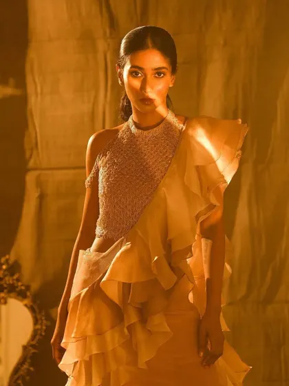 A portrait from the Nayantaara campaign. The makeup is clean and sophisticated, with a defined eye and glowing skin that stands out against the warm, dramatic lighting.