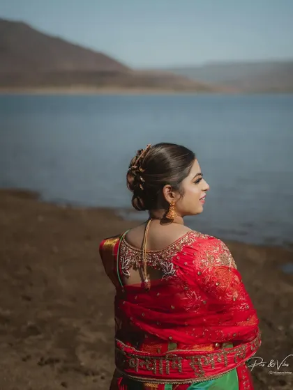 A close-up on the bride's intricate hairstyle and the beautiful design of her blouse, showcasing the details that make a bridal look special.