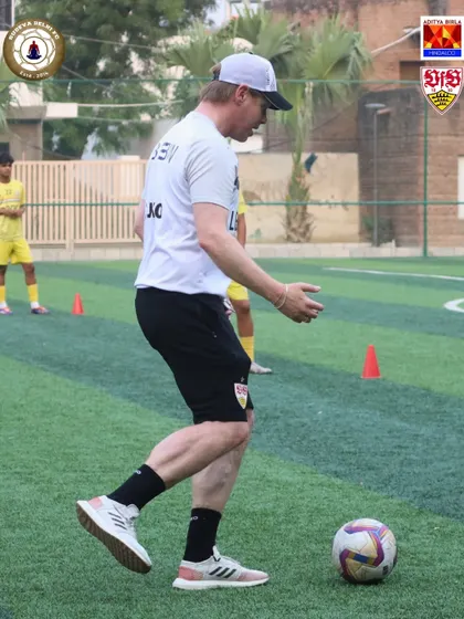 A VfB Stuttgart coach demonstrates proper technique. We believe in leading by example, and our international coaches actively participate in drills to show players the exact movements required.
