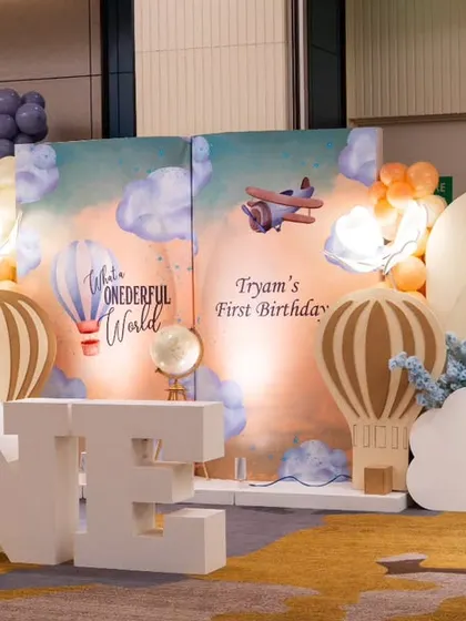 The full view of the "Wonderful World" first birthday theme. The large 'ONE' letters, cloud cutouts, and multiple hot air balloon props create a grand and impressive photo backdrop.