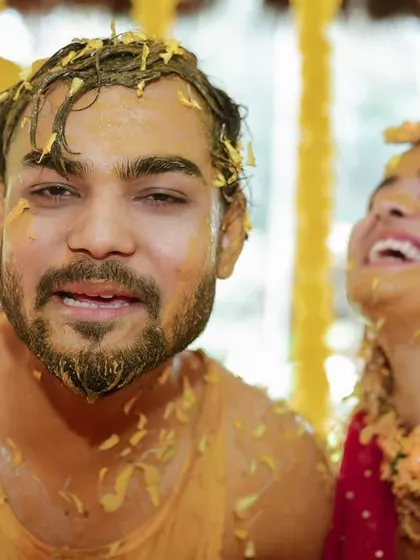 A candid shot capturing the couple's laughter during a messy and fun Haldi moment. Real emotions make the best photographs.