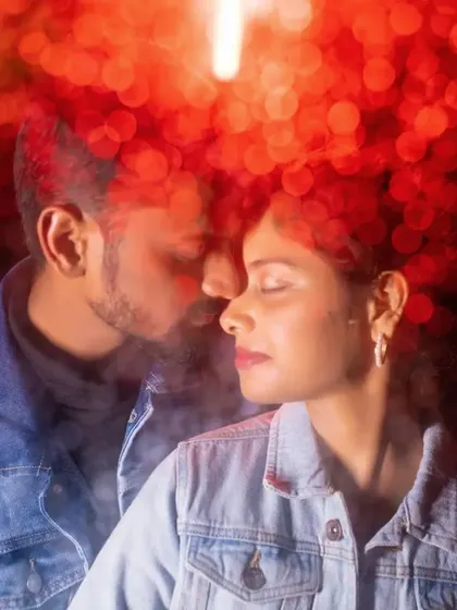 An intimate close-up of a couple surrounded by red bokeh lights. This creative lighting technique creates a passionate and dreamy atmosphere.