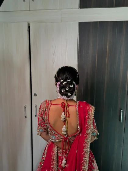 A view of the intricate floral bun from the back, showing how the flowers are woven into the hair for a classic and timeless bridal hairstyle.