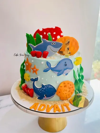 An underwater adventure cake featuring friendly whales and sharks, perfect for a little ocean explorer.