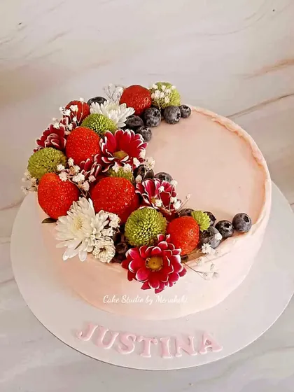 Sometimes, the freshest ingredients make the most beautiful cakes. This simple yet elegant design is topped with fresh strawberries, blueberries, and delicate flowers, creating a dessert that looks as good as it tastes.