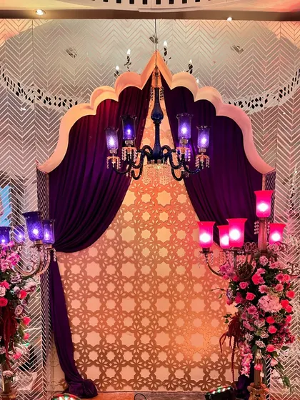 A photo opportunity spot with a grand arch, purple curtains, and ornate chandeliers, allowing guests to capture memories of the Turkish-themed night.