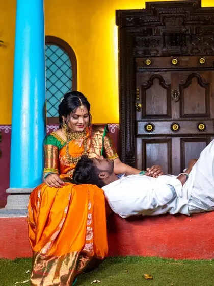 An intimate moment from their traditional photoshoot. The rich colors of their outfits and the rustic setting create a warm and authentic feel.