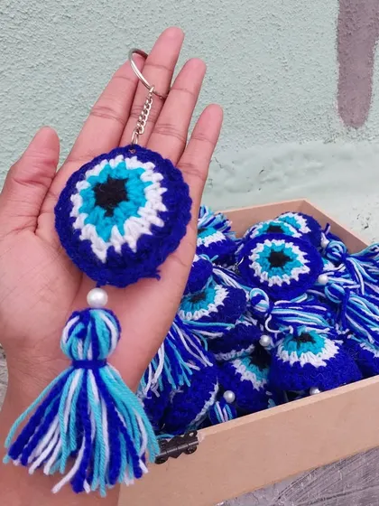 A close-up of my handmade evil eye keychain, showing the detailed crochet work and the colorful tassel. It's a perfect, handful-of-good-vibes gift.