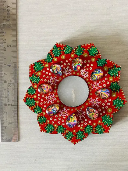 A festive, Christmas-themed floral candle holder in bright red with green accents and snowflake patterns. Perfect for the holiday season.