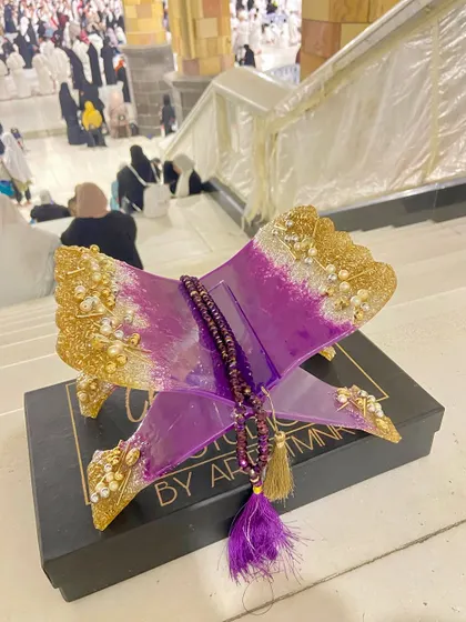 Another view of the purple and gold Quran holder in Makkah, capturing the spiritual energy of the place.