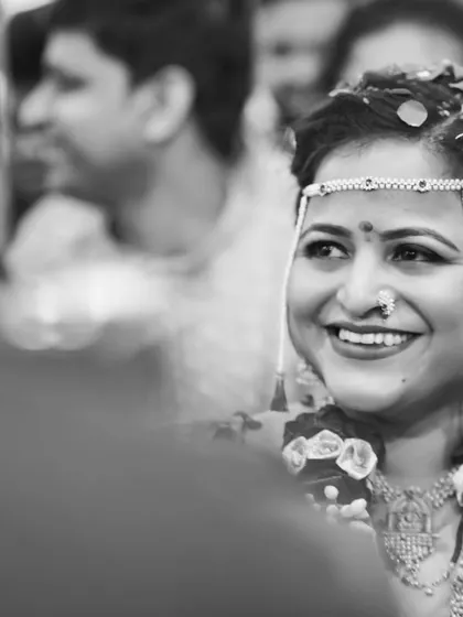 A beautiful black and white candid shot of the bride, her smile illuminated as she enjoys the wedding ceremony.