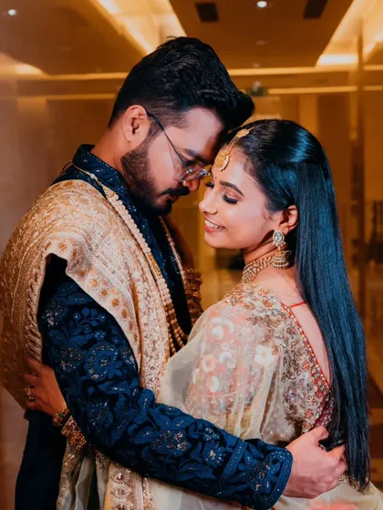 An elegant and intimate portrait of a couple on their wedding or reception day, showcasing their stunning traditional attire and close bond.