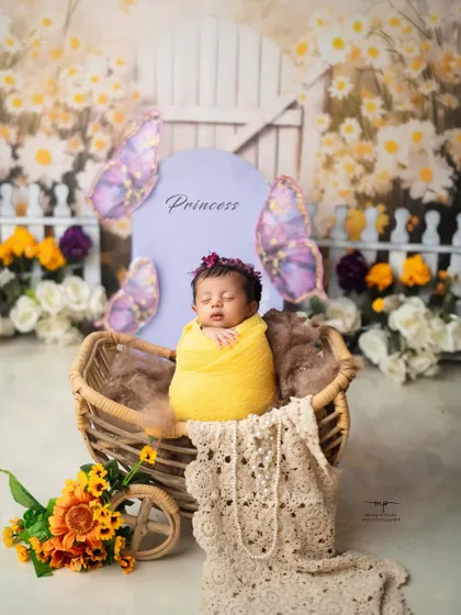 A little princess in her butterfly garden. The sign adds a sweet, personalized touch to this floral setup.