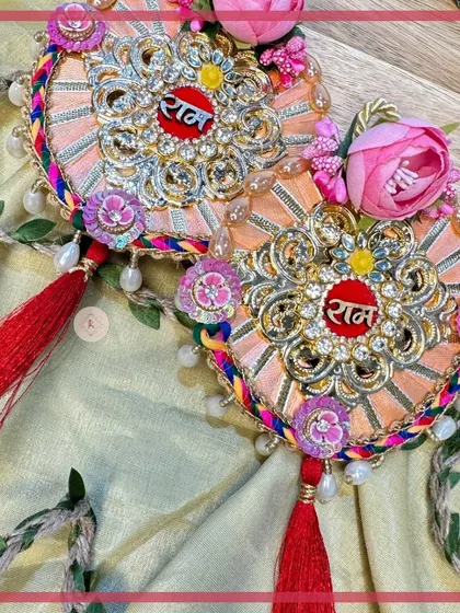 A beautiful peach-colored "Ram Ram" design with delicate floral accents and red tassels, blending tradition with contemporary style.