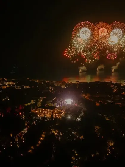 A spectacular fireworks display over the water, marking the grand finale of a multi-day celebration. We coordinate these large-scale moments to create a truly epic conclusion.