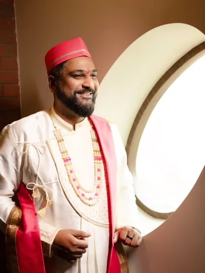 A smiling portrait of the groom, lit beautifully by a nearby window.