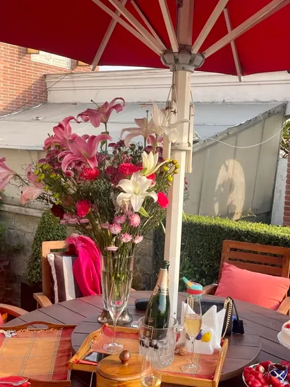 Nothing is more pleasurable than a party on a terrace garden. This setup, with champagne, cake, and a beautiful floral centerpiece, shows how a rooftop can become a private and elegant venue for celebrations.
