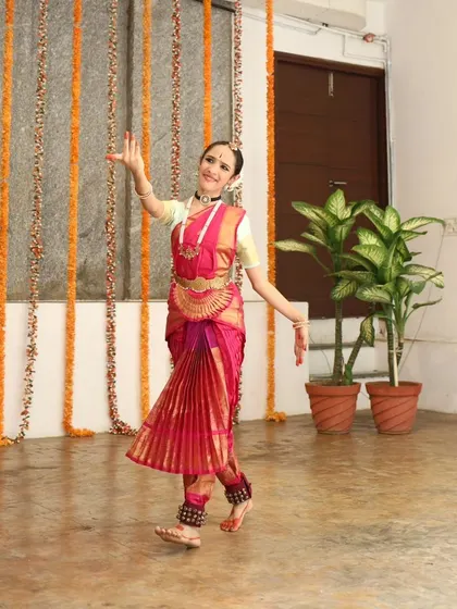 A young Bharatanatyam dancer in a vibrant costume.