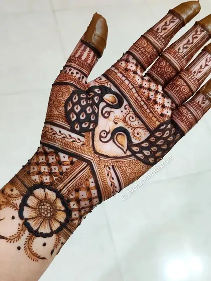 A full-palm design showcasing a beautiful peacock motif integrated with traditional Indian patterns. The detail work on the fingers and wrist completes the look.