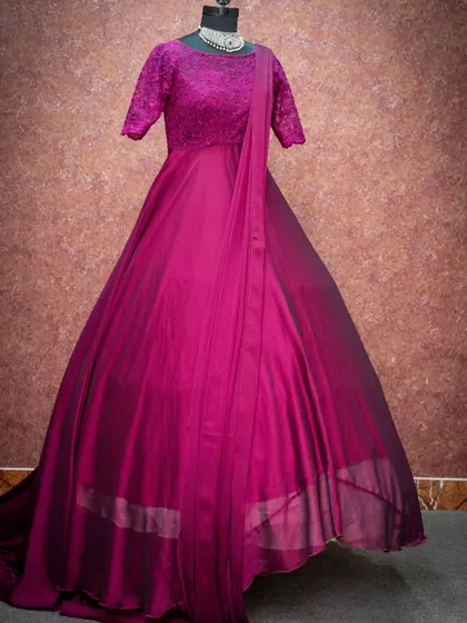 A beautiful magenta gown with a lace bodice and an attached dupatta-style drape, available for rent.