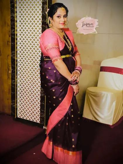 A client looking elegant for a naming ceremony. The dark purple and pink saree is paired with soft, glowing makeup.