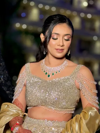 The bride's eyes are closed, showing the beautiful blend of shimmery eyeshadow for her sangeet glam.