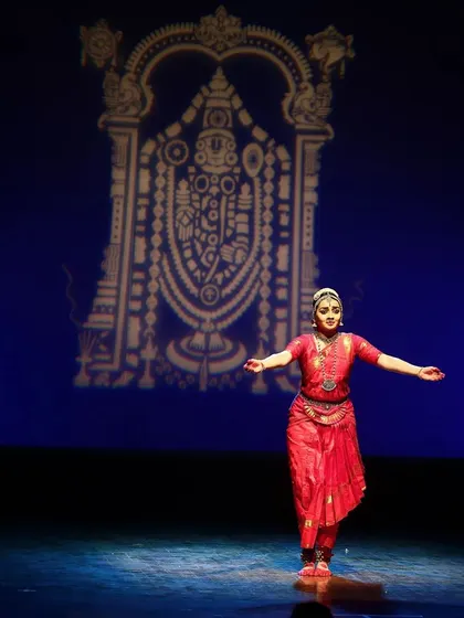 A full-stage shot showing my performance in front of the projected image of Lord Venkateshwara, creating a sense of scale and grandeur.