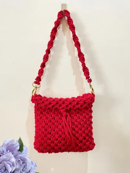 A bold and beautiful sling bag in a vibrant hot red. The simple, unlined design is lightweight and features a twisted strap with sturdy metal hardware.
